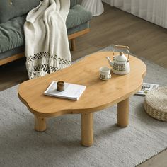 a wooden table sitting on top of a rug next to a couch