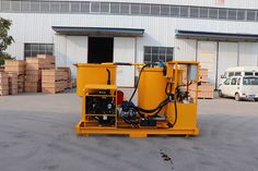 a large yellow machine sitting in front of a building