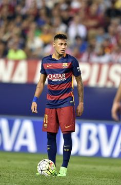 a soccer player standing on the field with a ball in his hand and people watching