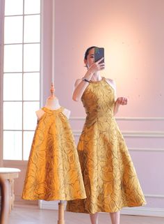 a woman taking a selfie with her cell phone in front of a mannequin