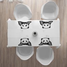 two panda bear urinals on top of a wooden floor next to toilet paper