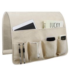 a cell phone and pen are in a pocket on the back of a canvas bag