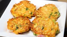 four fritters on a white plate being held by a person