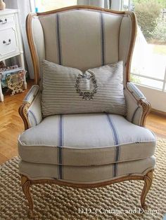 a chair with a pillow on it in front of a window