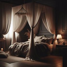 a bed with white drapes and pillows in a dark room