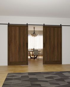 an open sliding door in a living room with hardwood floors and white walls, along with a rug on the floor