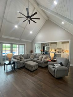 a living room filled with furniture and a ceiling fan in the middle of the room