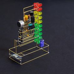 a multicolored rack holds several small items on it's sides and is made out of metal wire