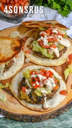 some tacos are sitting on a wooden plate