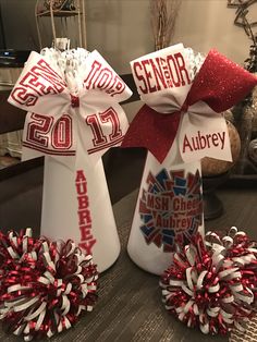 two white vases with red and white pom poms