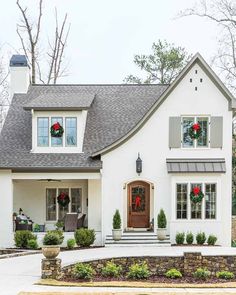 a white house with wreaths on the front door