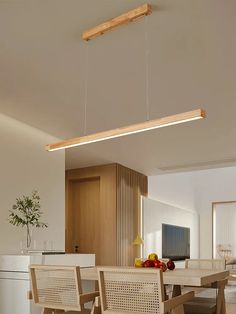 a dining room table and chairs with lights hanging from the ceiling