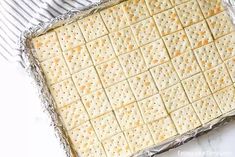 crackers are placed on top of a sheet of tin foil in a baking pan