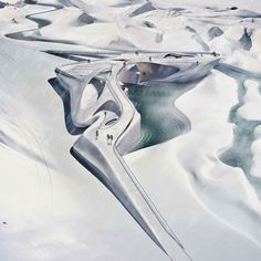 an artist's rendering of a futuristic building in the middle of snow covered mountains