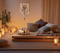 a bed with pillows and candles in front of a wall hanging on the wall next to it