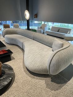 a curved couch sitting in the middle of a living room