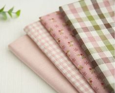 four pink and green checkered cloths sitting next to each other on a table