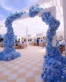 an outdoor wedding venue with blue flowers on the pillars