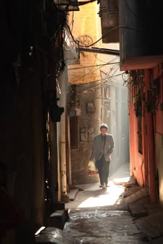 a man is walking down an alley way