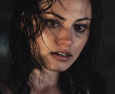 a close up of a woman with wet hair and makeup looking at the camera,