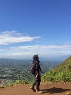 a person standing on top of a hill looking out at the valley and hills in the distance