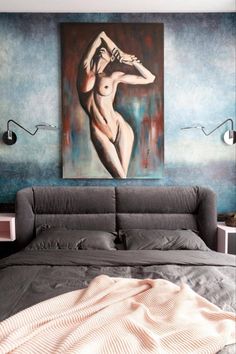 a bed with a painting on the wall above it