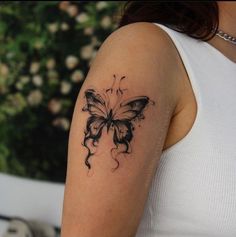 a woman's arm with a butterfly tattoo on the left side of her arm