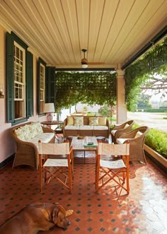 an instagram photo of a porch with wicker furniture and green shuttered windows