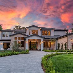 a large house with lots of windows on the front and side of it at sunset