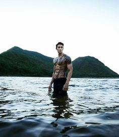 a man standing in the water with his shirt off