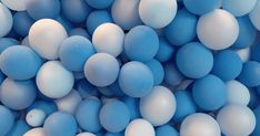 many blue and white balloons are scattered together