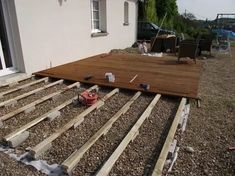 a wooden deck is being built on the side of a house with wood slats laid out around it