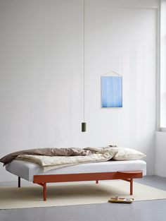 a bed sitting on top of a white floor next to a window