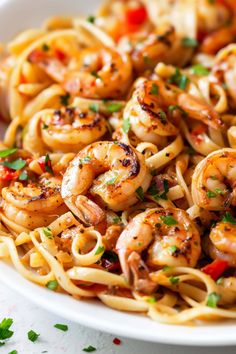 pasta with shrimp and tomato sauce in a white bowl