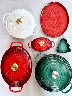 four red and green dishes are sitting on a white tablecloth, one is holding a gold star