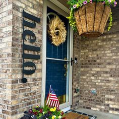 an american flag is on the front door of a brick building with a welcome sign