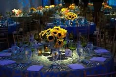 the table is set with sunflowers and place settings for guests to sit at