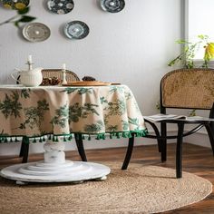 two chairs and a table in a room with plates on the wall behind it,