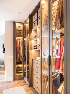 a walk in closet filled with lots of drawers and clothes on top of wooden shelves