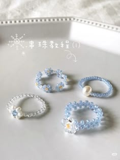 four bracelets are sitting on a table with snowflakes and beads around them