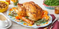 a turkey sitting on a table with other thanksgiving foods