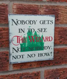 a sign that is on the side of a brick wall saying nobody gets in to see the wizard not nobody, not no how?