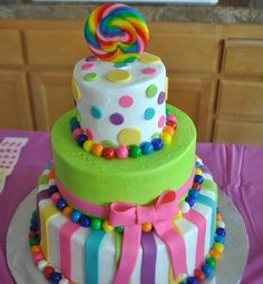 a multi layer cake decorated with candy and lollipops