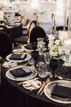 a table set with black and gold place settings