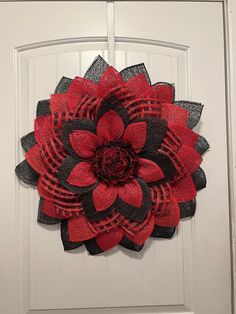 Looking for a wreath that stand out in a crowd.  Check out this large flower wreath. Red, black and a red and black check poly burlap has been shaped into flower petals.  Each petal has been secured to a plastic wreath board with a zip tie.  The center is black and red fuzzy ribbon secured to a Styrofoam center with a professional strength glue. This flower wreath measures approximately 2 feet in diameter and only about 2 inches deep so it can go between a door and storm door with no issues. Black Red Wreath, Valentine Wreaths, Storm Door, Valentine Wreath, Zip Ties, Black Flower, Door Wreath Hanger, Large Flowers, Flower Wreath