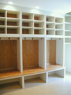 an empty room with white shelves and wooden benches