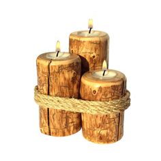 three wooden candles sitting on top of each other with rope wrapped around the logs and wood