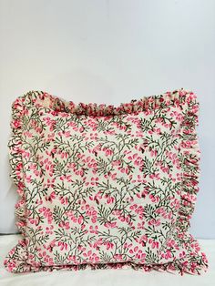 a pillow with pink flowers and green leaves on it