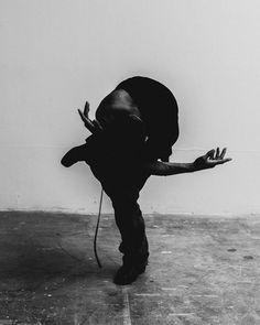 black and white photograph of a man doing a handstand on the floor with his arms stretched out