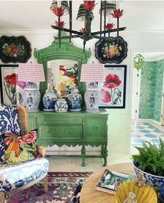 a living room filled with lots of furniture and flowers on top of a green table